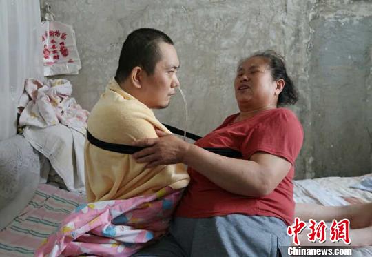 身體日漸衰老的梁青蘭每次幫兒子翻身、坐立，全身的衣物都要濕透一次?！∩忻鱾b 攝