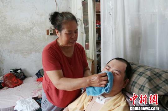 每次喂完食物后，梁青蘭都要仔細(xì)地幫兒子清理干凈。　尚明俠 攝