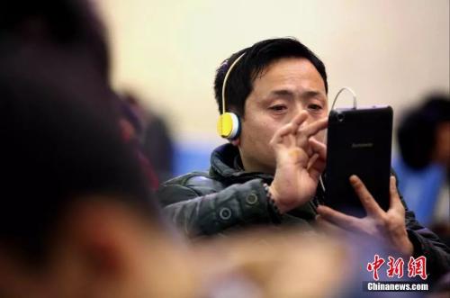 資料圖：候車(chē)室內(nèi)，玩手機(jī)的&ldquo;低頭族&rdquo;隨處可見(jiàn)。刷微博、聊微信、玩游戲、看電影，高科技將大多旅客變?yōu)槭謾C(jī)&ldquo;低頭族&rdquo;。<a target='_blank' ><p  align=