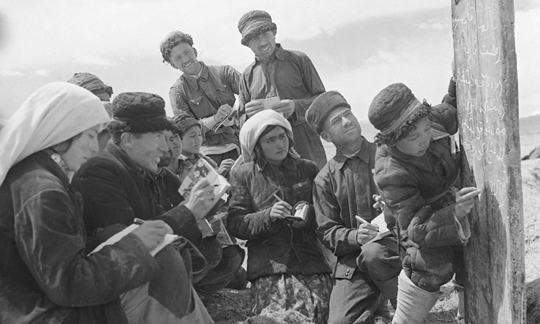1960年6月，新疆慕士塔格峰下，大人們在小學(xué)生幫助下學(xué)習(xí)文化。新華社記者武純展攝
