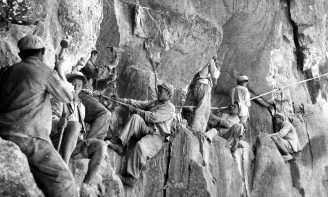 1954年，修筑康藏公路的解放軍戰(zhàn)士們在怒江兩岸的懸崖陡壁上辟山筑路。新華社稿 李萬春、張加里攝