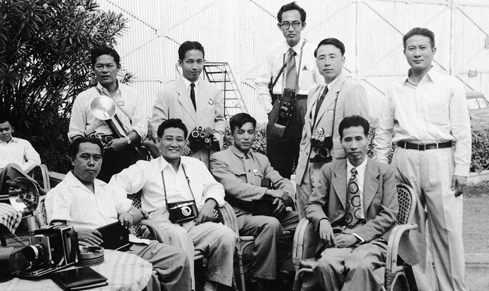 新華社記者錢嗣杰（站立者右二）在采訪會議開幕式后和外國記者在會場外休息。