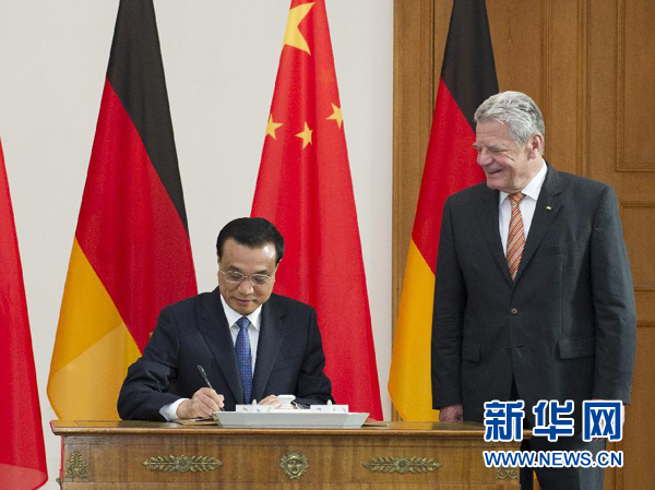 10月10日，國務(wù)院總理李克強在柏林會見德國總統(tǒng)高克。這是李克強總理在高克總統(tǒng)的陪同下在貴賓簿上簽字。 新華社記者 王曄 攝 